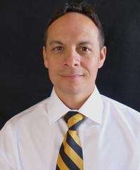 dr. olvera smiles in front of a black background | dentist st petersburg fl